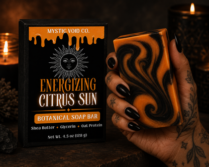 Botanical soap bar with packaging labeled 'Energizing Citrus Sun' held by a hand against a dark background.
